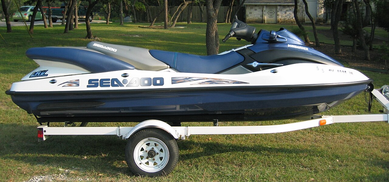 A Sea-Doo jet ski on a trailer parked on grass